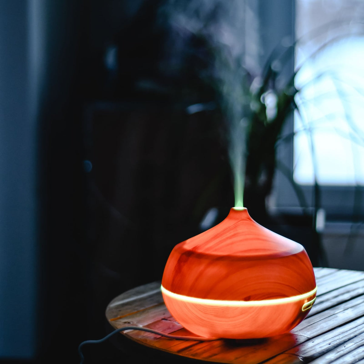 Diffuser misting on a small wooden table by a window